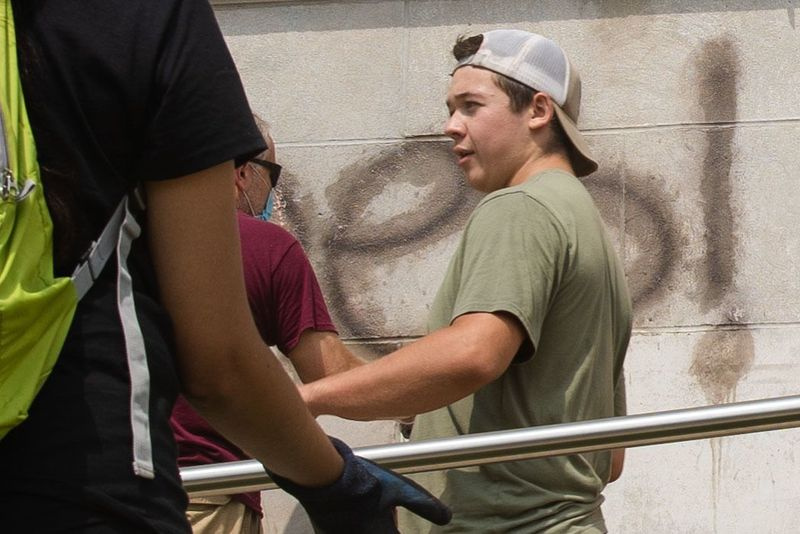 Kyle Rittenhouse, ki je obtožen smrtnega ustrelila dveh protestnikov in ranjenega tretjega torka zvečer v Kenoshi v Wisconsinu, pomaga čistiti zunanjost srednje šole Reuther Central High School v torek zjutraj.