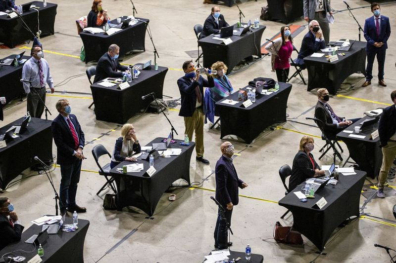 Na tej fotografiji datoteke z dne 23. maja 2020 zakonodajalci spremljajo vsote glasov za zakon o igralnicah v Chicagu v Bank of Springfield Center v Springfieldu, kjer je imela seja Illinois House, da bi omogočila varno socialno distanciranje med pandemijo.