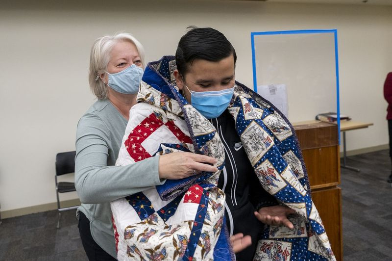 Mereväe veteran Arturo Garza mähib Quilts of Valori vabatahtliku Beverly Schulze tekki.
