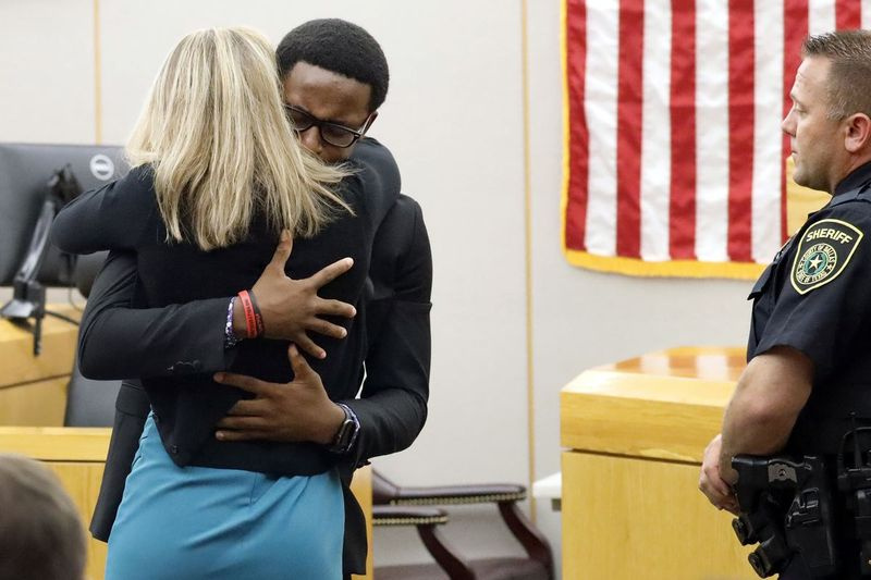 El hermano menor de Botham Jean, Brandt Jean, abraza al asesino convicto y ex oficial de policía de Dallas, Amber Guyger, luego de que fuera sentenciada a 10 años de prisión.