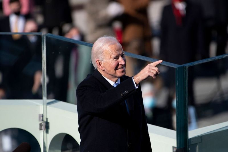 Prezident Joe Biden poukazuje na hostí, ktorí sa v stredu zúčastňujú jeho inaugurácie na západnom fronte Kapitolu USA.