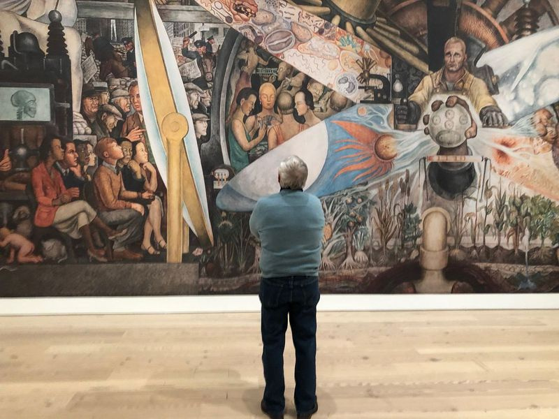 Um visitante do Whitney Museum em Nova York contempla uma reprodução de Man, Controller of the Universe, de Diego Rivera.