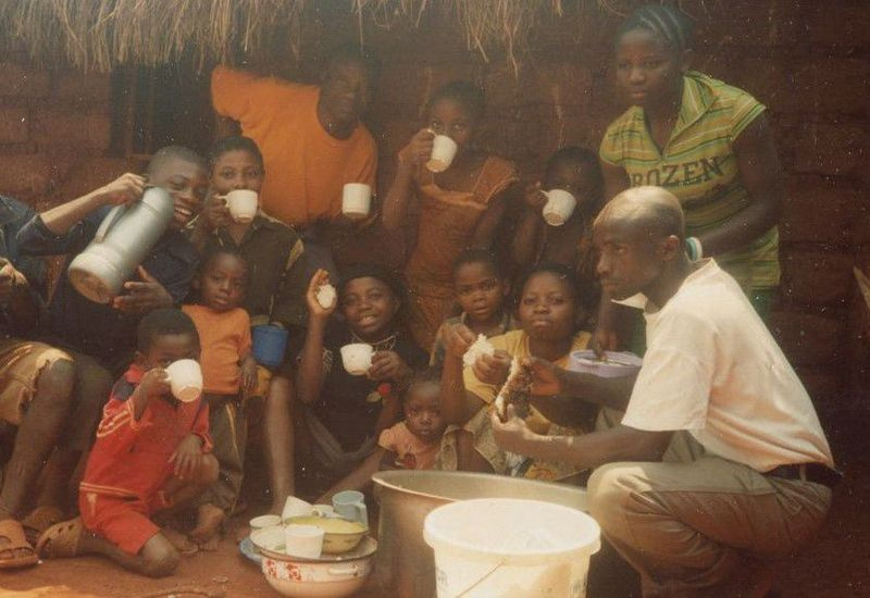 Mapenzi Mweniake, der står til højre med ROZEN på blusen, bliver vist sammen med sin udvidede familie i Nyarugusu Flygtningelejr i Tanzania, inden hun kommer til Chicago i 2016.