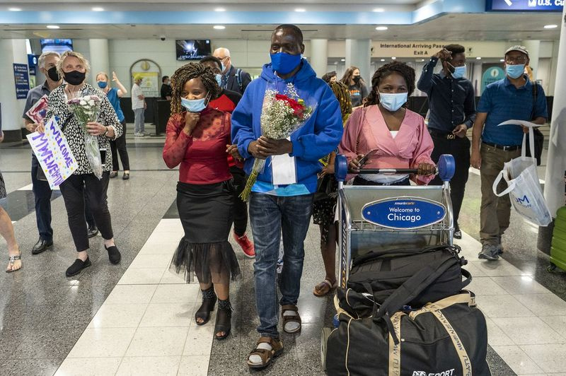 Mwenebatu Mwenemkaba, i midten, går med sin kone Mapenzi Mweniake, tredje fra højre, ud af O