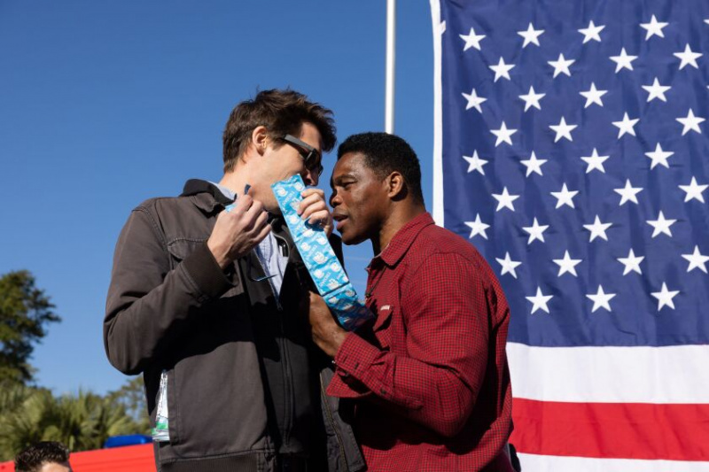   En demonstrant præsenterer kondomer til det republikanske senat-nominerede Herschel Walker, da han forlader scenen under et kampagnestop den 20. oktober 2022 i Macon, Georgia. Walker stillede op mod den siddende senator Raphael Warnock (D-GA) ved midtvejsvalget.