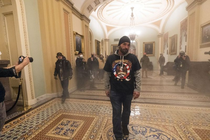 Dym zapĺňa chodník pred sálou Senátu, keď sú prívrženci prezidenta Donalda Trumpa konfrontovaní s dôstojníkmi americkej Capitol Police v stredu v Capitole.