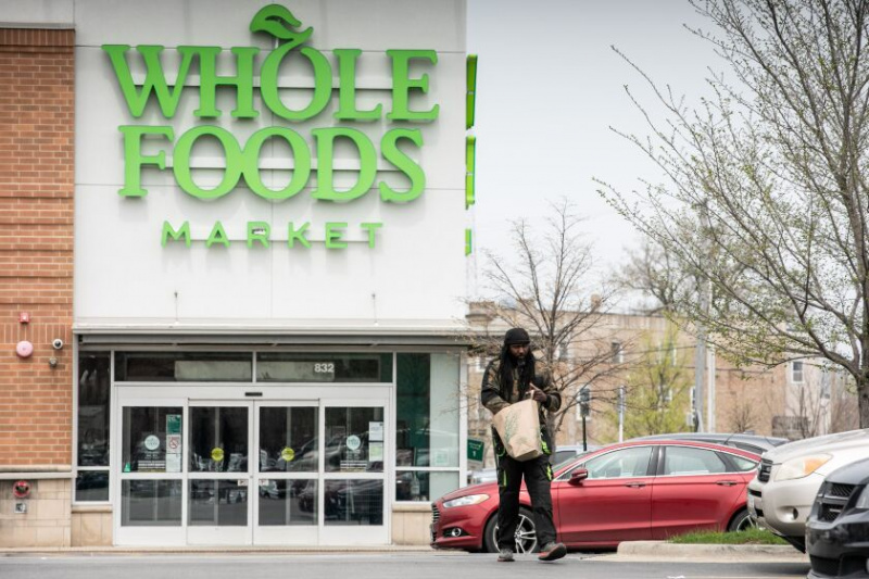   Pirkėjas išeina iš „Whole Foods Market“ Englvude tą dieną, kai bendrovė paskelbė, kad parduotuvė bus uždaryta.