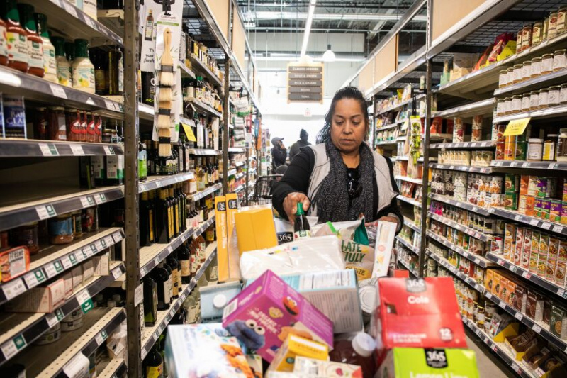   52 metų Emma Morales į krepšelį įdeda butelį alyvuogių aliejaus per išpardavimą „Whole Foods“ Englevude prieš parduotuvės uždarymą.