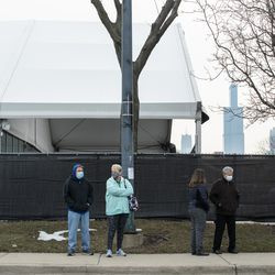 Människor ställer upp utanför massvaccinationsplatsen för COVID-19, som sattes upp på parkeringsplatsen vid United Center i stadsdelen Near West Side, på öppningsdagen för den nya massvaccinationsplatsen, tisdagsmorgonen den 9 mars 2021.