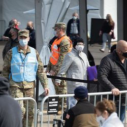 Människor går utanför covid-19 massvaccinationsplatsen som sattes upp på parkeringsplatsen vid United Center i Near West Side-området på öppningsdagen för den nya massvaccinationsplatsen, tisdag morgon den 9 mars 2021