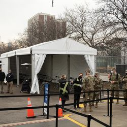 Medlemmar av Illinois National Guard står utanför massvaccinationsplatsen för COVID-19 som sattes upp på parkeringsplatsen vid United Center.
