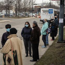 Människor ställer upp utanför massvaccinationsplatsen för COVID-19, som sattes upp på parkeringsplatsen vid United Center i stadsdelen Near West Side, på öppningsdagen för den nya massvaccinationsplatsen, tisdagsmorgonen den 9 mars 2021.