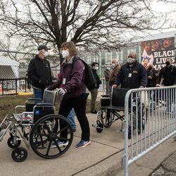 Människor ställer upp utanför massvaccinationsplatsen för COVID-19, som sattes upp på parkeringsplatsen vid United Center i stadsdelen Near West Side, på öppningsdagen för den nya massvaccinationsplatsen, tisdagsmorgonen den 9 mars 2021.