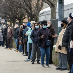 Människor ställer upp utanför massvaccinationsplatsen för COVID-19, som sattes upp på parkeringsplatsen vid United Center i stadsdelen Near West Side, på öppningsdagen för den nya massvaccinationsplatsen, tisdagsmorgonen den 9 mars 2021.