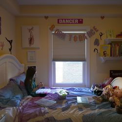 Hayley Orlinsky fertigt im Schlafzimmer ihres Hauses in Chicago ein Armband aus bunten Gummibändern.