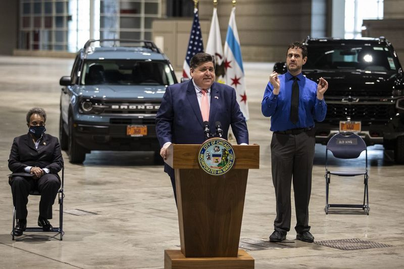 Gubernator J.B. Pritzker przemawia podczas konferencji prasowej w McCormick Place we wtorek rano, gdy burmistrz Lori Lightfoot słucha.