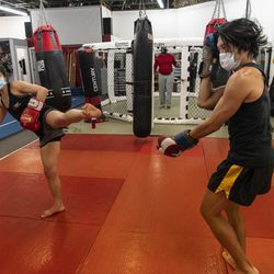 Jun Phan, a la izquierda, estudiante de EFK Martial Arts, 5951 N. Clark St., entrena con el propietario y entrenador en jefe Anthony Márquez durante una clase de boxeo el primer día de la reapertura de la Fase 4 de Illinois, el viernes 26 de junio de 2020.