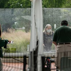 El personal del zoológico de Lincoln Park le da la bienvenida a un visitante el primer día de la reapertura de la Fase 4 de Illinois, el viernes 26 de junio de 2020 por la tarde.