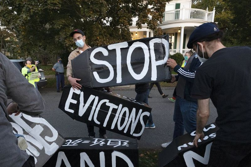 Activiștii pentru locuințe dețin pancarte care protestează împotriva evacuărilor din octombrie 2020. Moratoriul federal privind evacuarea urmează să fie ridicat pe 31 martie 2021.