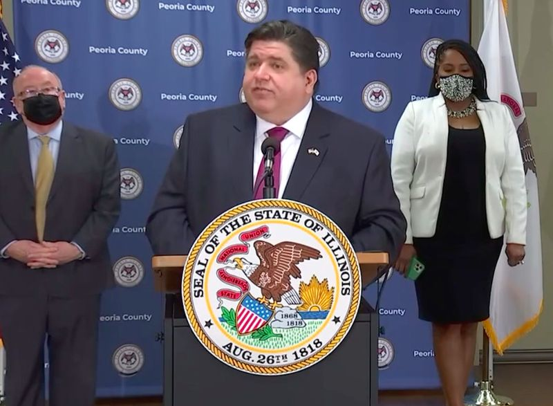Gabenor J.B. Pritzker (tengah) bercakap Rabu di tapak vaksinasi West Peoria.
