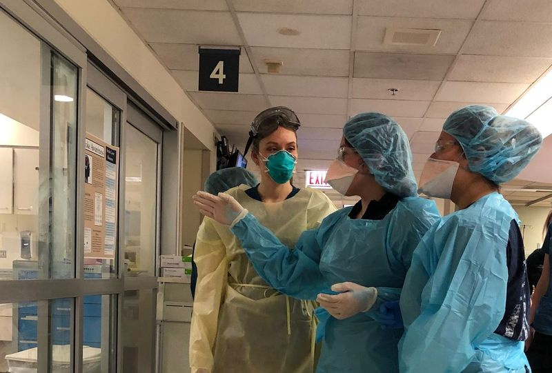 Medicīnas darbinieki, kuri valkā individuālos aizsardzības līdzekļus, konsultējas Sinaja kalna slimnīcas neatliekamās palīdzības nodaļā, kas ir sagatavota Covid-19 pacientu pieplūdumam nākamo divu nedēļu laikā.