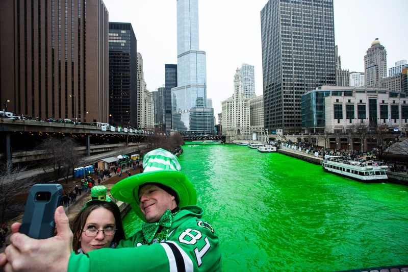 Stacey Peterson och Kevin McGuire tar en selfie med den gröna Chicago River för att fira St. Patrick