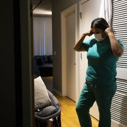Slaugytoja praktikuojanti slaugytoja Capri Reese nusiima veido kaukę, dezinfekuoja batus ir įdeda šveitiklius į skalbimo mašiną, prieš iš karto nusiprausdama po dušu South Loop bute po 12 valandų pamainos Roseland bendruomenės ligoninėje, kur mirė trys nuo COVID-19 sergantys pacientai, antradienį. 2020 m. balandžio 28 d., popietė.