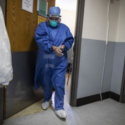 Slaugytoja nusiima pirštines, išeidama iš paciento kambario po to, kai 56 metų moteris, serganti COVID-19, antradienio popietę Rozlando bendruomenės ligoninėje Tolimųjų Pietų pusėje paskatino greitą reagavimą, ty kvėpavimo ar širdies sustojimą. , 2020 m. balandžio 28 d.