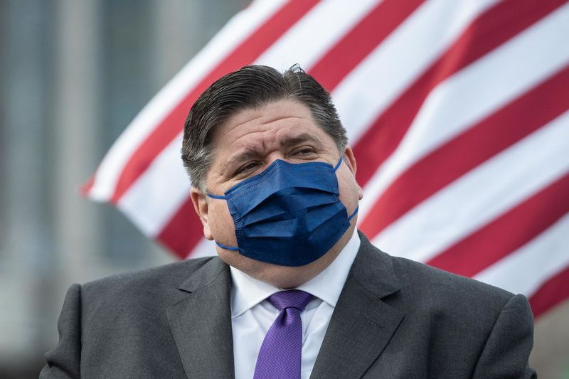 Guvernör J.B. Pritzker lyssnar under en presskonferens om öppningen av den nya COVID-19 massvaccinationsplatsen på parkeringsplatsen vid United Center i Near West Side-kvarteret förra veckan.
