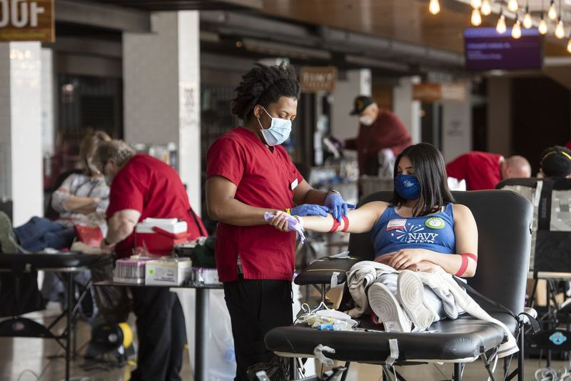 En røde Kors phlebotomist binder en kvindes arm med medicinsk tape, efter at hun gav blod, ved en Røde Kors blodkørsel på Navy Pier, mandag den 4. maj 2020. | Tyler LaRiviere/Sun-Times