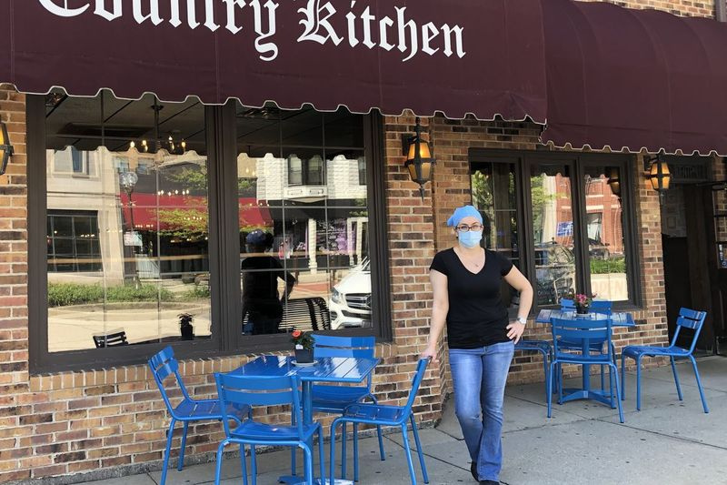 I fredags forestod Ruby Iliopoulos, leder af Country Kitchen, en institution i Highland Park, nye, blå udendørs spiseborde, mens den store bagparti blev asfalteret, så restauranten kan rejse et telt til endnu mere udendørs spisning. Vi tilpasser os til dette næste skridt og starter op igen lidt efter lidt, sagde hun.
