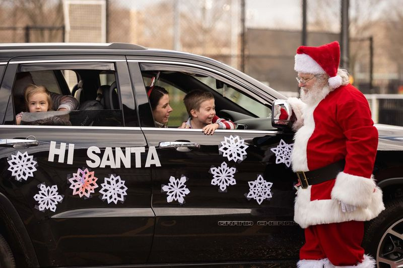 Tina Lamkey y sus hijos Owen y Nora saludan a Santa Claus en el parque Keystone en River Forest en diciembre de 2020. Las autoridades dicen que la temporada navideña de 2021 puede parecer más normal gracias a las vacunas, pero aún recomiendan practicar el distanciamiento social.