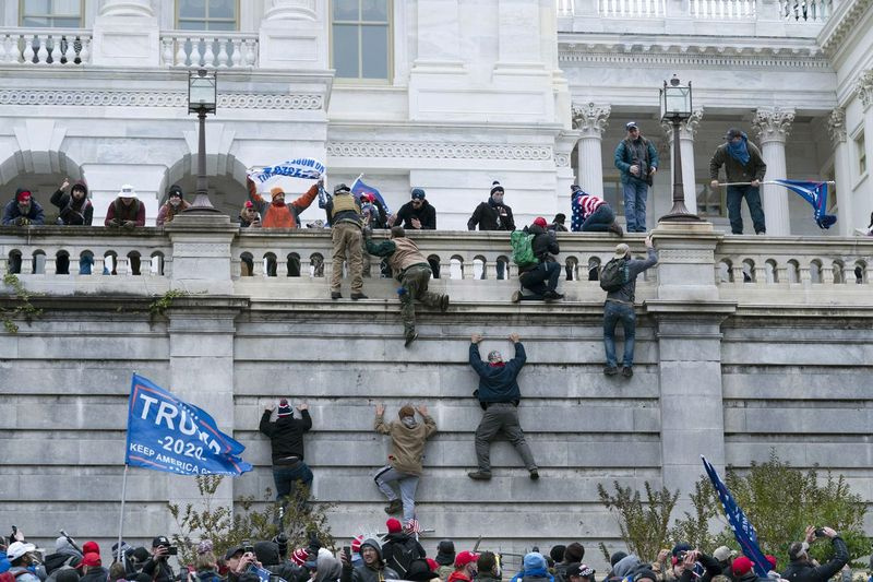 Les partisans de Donald Trump escaladent le mur ouest du Capitole américain le 6 janvier.