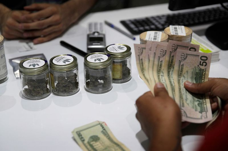 ARQUIVO - Nesta foto de arquivo de 1º de julho de 2017, uma pessoa compra maconha no dispensário de cannabis Essence em Las Vegas. (AP Photo / John Locher, Arquivo) ORG XMIT: LA538