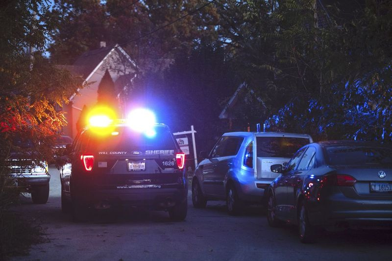 Sekmadienio vakarą prie namo stovi policijos automobilis, kur per šaudynes sekmadienio pradžioje per Helovino vakarėlį Džoliet miestelyje buvo sužeista daugiau nei 12 žmonių, du iš jų mirtinai.
