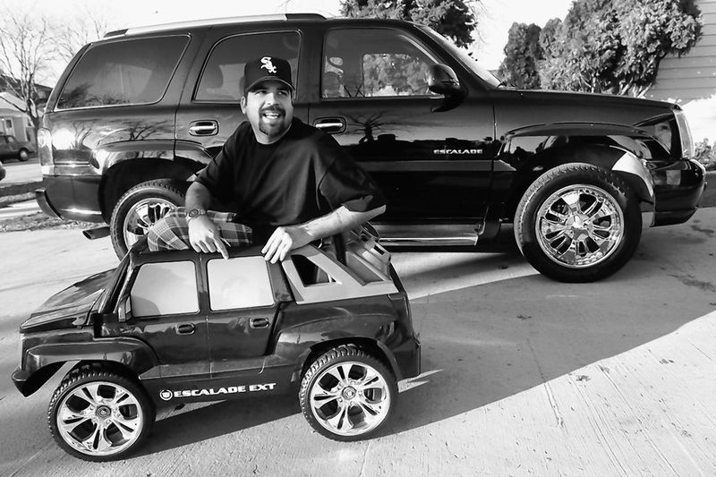 Ēriks Jagličičs, pazīstams arī kā Blaxican, sēž mini Cadillac Escalade ar savu pilna izmēra automašīnu fonā 2006. gadā.