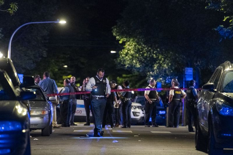 A polícia de Chicago trabalha na cena em que pelo menos 8 pessoas foram baleadas no bloco 6300 da South Artesian Ave no bairro de Marquette Park, domingo, 27 de junho de 2021.
