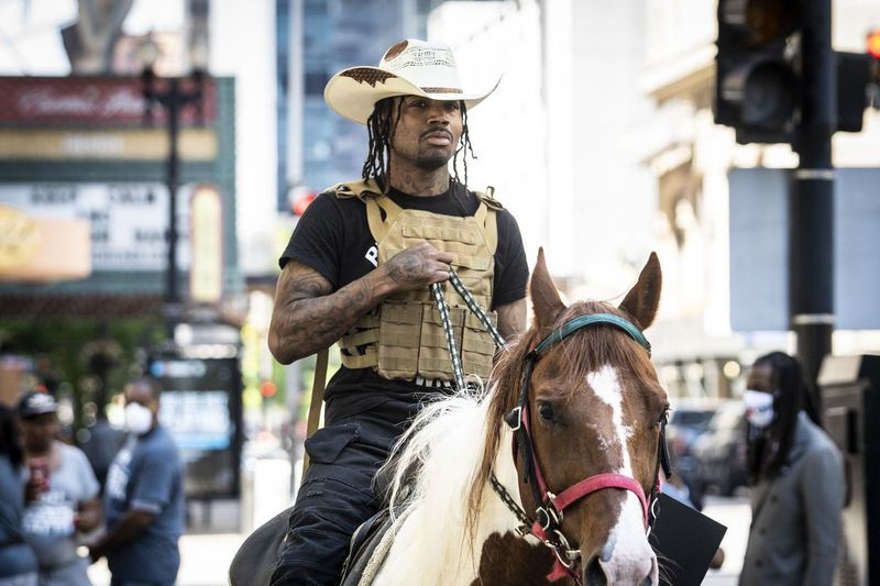 Adam Hollingsworth, também conhecido como The Dread Head Cowboy, monta seu cavalo Prince in the Loop em 16 de junho de 2020.