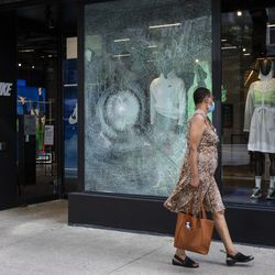 Sieviete iet garām Nike 669 N. Michigan Ave. Magnificent Mile pēc tam, kad naktī Loop un apkārtējos rajonos notika laupīšana pirmdienas rītā, 2020. gada 10. augustā.