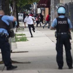 Čikāgas policisti reaģē uz šāvieniem, kas tika raidīti pie ziņojumiem par laupīšanu un nekārtībām West Madison Street netālu no South Karlov Avenue West Side, pirmdienas pēcpusdienā, 2020. gada 10. augustā.