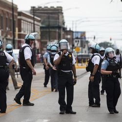 Čikāgas policijas Cmdr. Ernests Kato (centrā), kopā ar citiem virsniekiem, reaģē uz ziņojumiem par izlaupīšanu un nemieriem netālu no West Madison Street un South Karlov Avenue West Side, pirmdienas pēcpusdienā, 2020. gada 10. augustā.