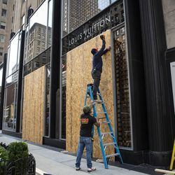 2020. gada 10. augusta pirmdienas rītā Luisa Vuitton veikala 919 N. Michigan Ave. — Magnificent Mile apgabalā strādā pie logiem.