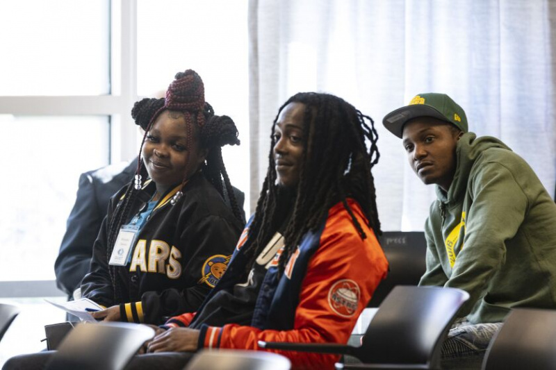   Michelle Dennis iš kairės, Jarellas Davisas ir Charlesas Tayloras klausosi pastabų ketvirtadienį North Lawndale Atkuriamojo teisingumo bendruomenės teismo diplomų įteikimo ceremonijoje.