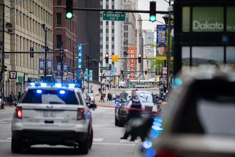 Os carros da polícia estão estacionados perto da West Grand Avenue e North State Street no bairro de River North depois que três pessoas foram baleadas no sábado em um estacionamento no primeiro quarteirão da West Grand Avenue, de acordo com a polícia de Chicago.
