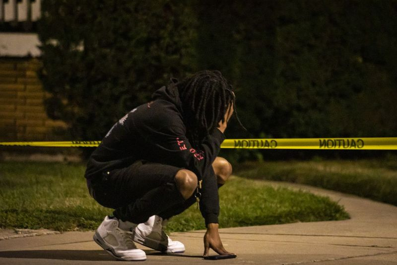 En mand reagerer på stedet, efter at en 22-årig mand tidligt mandag blev skudt i ansigtet i en baggård i 9500-blokken på South Yale Avenue i Longwood Manor på South Side.