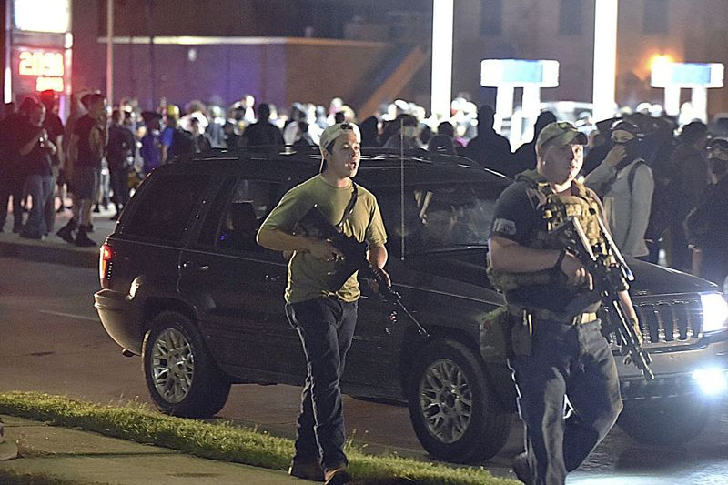 Kyle Rittenhouse (vänster, med bakåtvänd mössa) går längs Sheridan Road i Kenosha, Wisconsin, den 25 augusti 2020, tillsammans med en annan beväpnad civil.