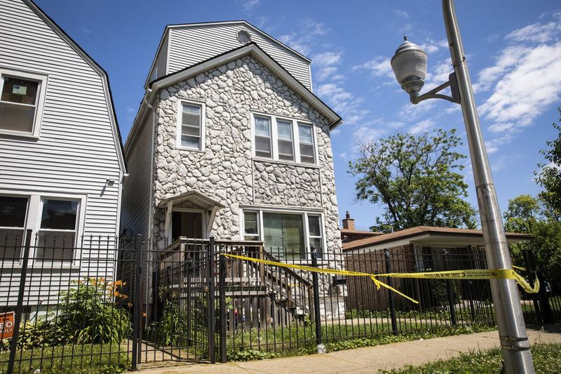 La polizia di Chicago vigila martedì pomeriggio e il nastro della scena del crimine è appeso fuori da una casa nel blocco 6200 di South Morgan, dove otto persone sono state colpite, quattro mortalmente, all