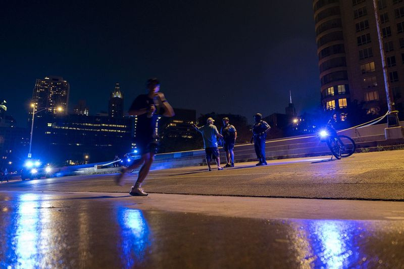 Een man rent voorbij terwijl de politie van Chicago maandagavond onderzoek doet nadat een persoon is neergeschoten op de Lakefront Trail nabij het 800-blok van North Lake Shore Drive in de wijk Gold Coast.