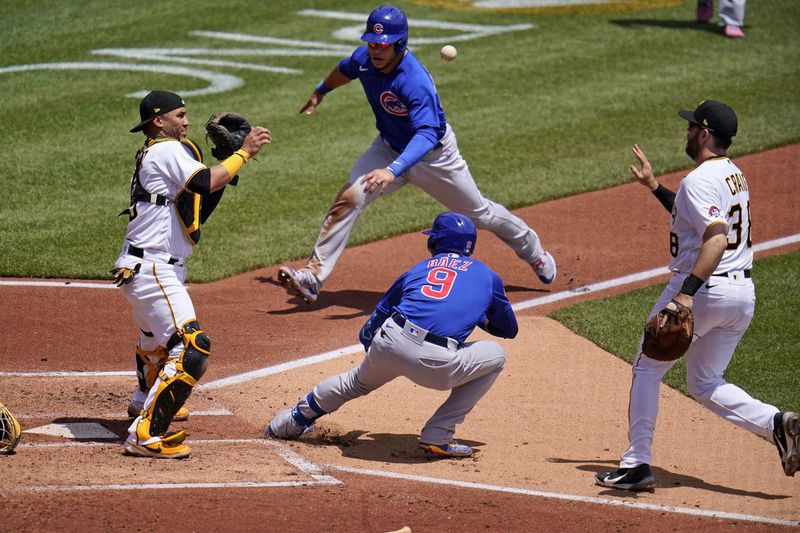 Le joueur de premier but des Pirates Will Craig, à droite, lance le ballon au receveur Michael Perez, à gauche, après que les Cubs Javier Baez (9) ont frappé le choix d