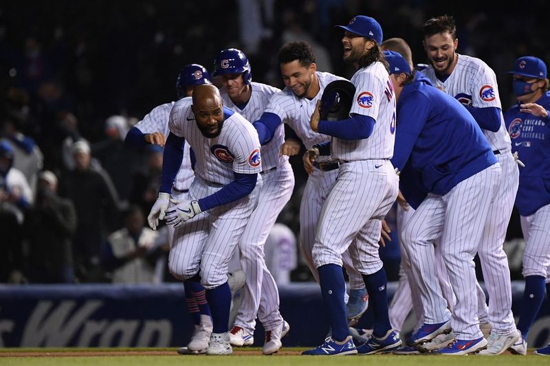 Jasoną Heywardą persekioja jo Cubs komandos draugai po to, kai ketvirtadienį 10-oje pamainoje laimėjo RBI singlą.